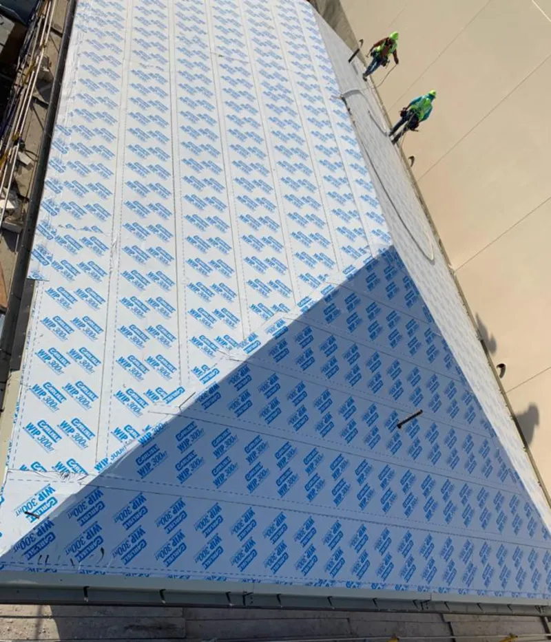 Professional roofers installing underlayment on a metal roof in La Grange Park